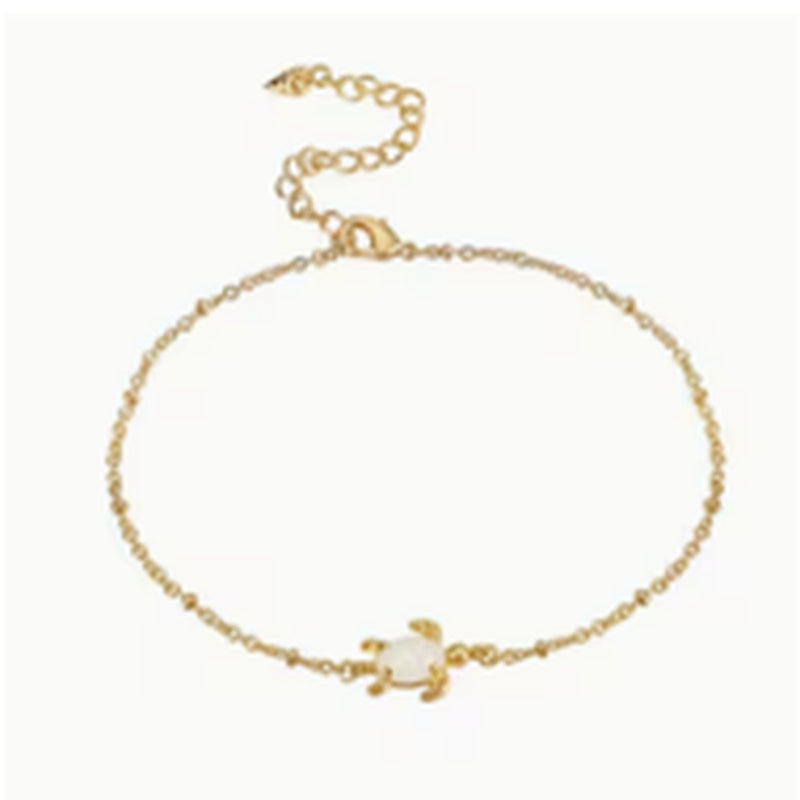 Fine gold-tone anklet with a small flower charm